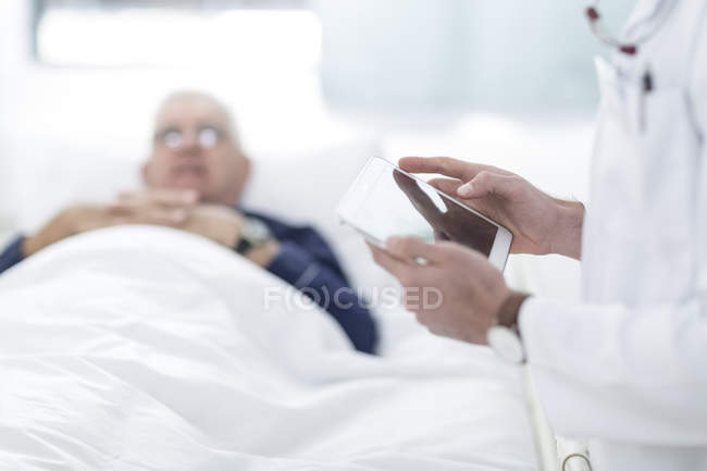 Close-up do médico usando um comprimido digital ao lado do paciente — Fotografia de Stock