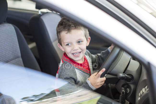 Rapaz feliz no carro revendedor dentro carro direção — Fotografia de Stock