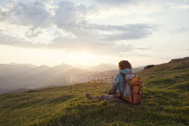Austria, Tyrol, Unterberghorn, hiker resting in alpine landscape at sunrise — Stock Photo