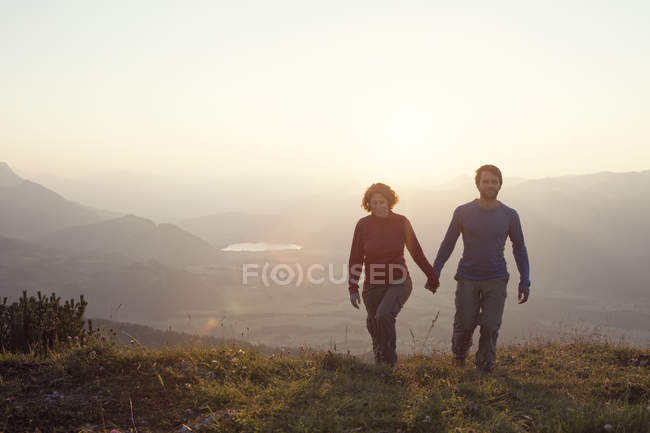 Österreich, Tirol, Paar geht Hand in Hand am Unterberghorn bei Sonnenuntergang — Stockfoto