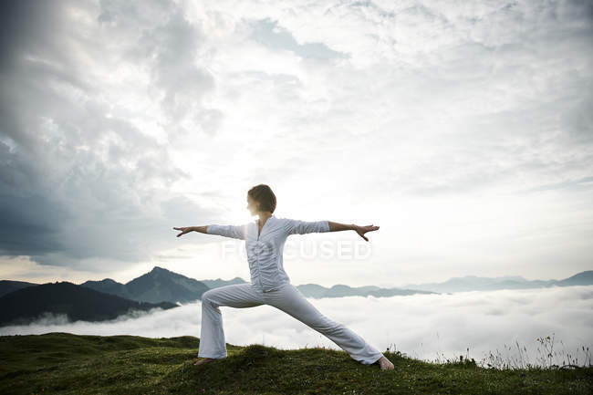 Austria.Kranzhorn, Mid adult woman practising yoga on mountain top — Stock Photo