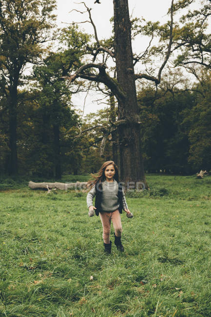 Little girl running on a meadow in a park — Stock Photo