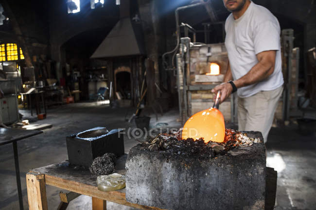 Людиною покласти розплавленого скла в прес-форму в скляного заводу — стокове фото