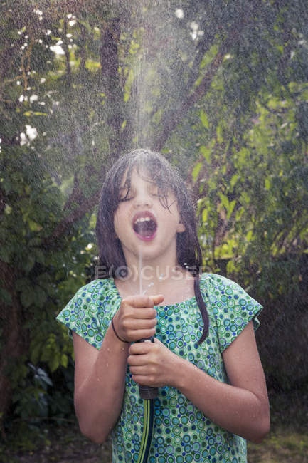 Ragazza che si raffredda con tubo da giardino — Foto stock