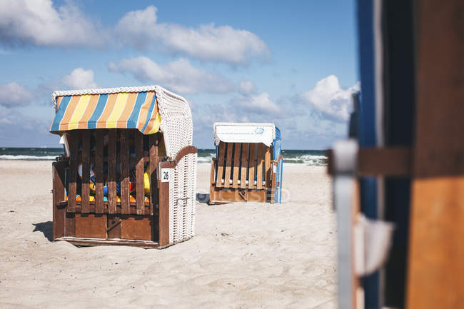 Germania, Meclemburgo-Pomerania occidentale, Warnemuende, sedie a sdraio chiuse con cappuccio sulla spiaggia — Foto stock