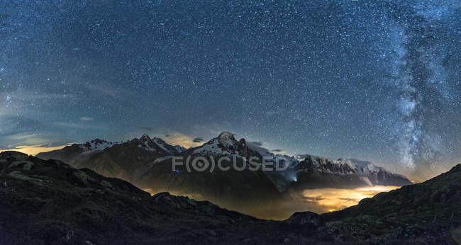 França, Mont Blanc, Lago Cheserys, Via Láctea e Monte Blanc à noite com o vale iluminado pelas luzes da cidade de Chamonix — Fotografia de Stock