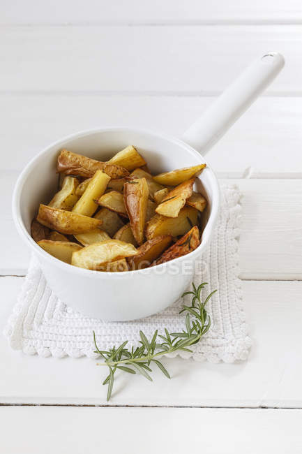 Casserolle of potato wedges with rosemary — Stock Photo