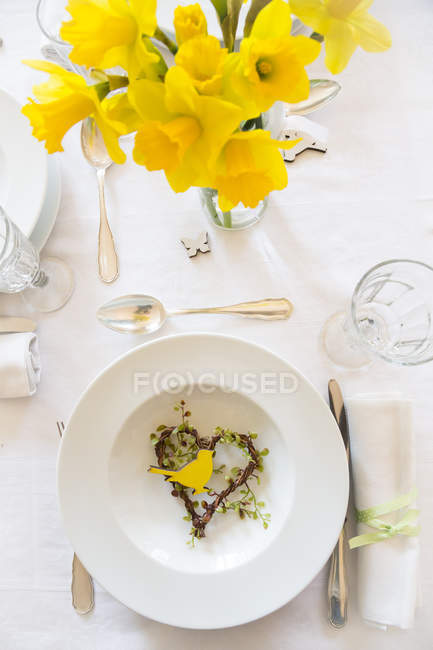 Colocación en mesa colocada con narcisos en primavera - foto de stock