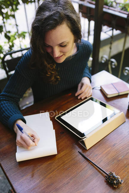 Giovane donna seduta sul balcone, che lavora con tablet digitale — Foto stock