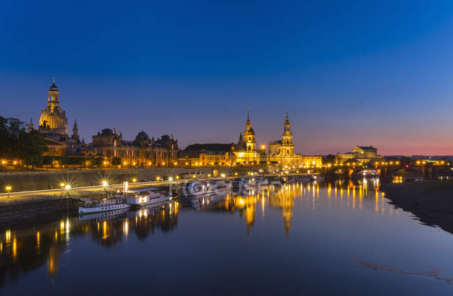 Німеччина, Саксонії, Дрезден, освітлена Старого міста з Ельби на передньому плані вночі — стокове фото