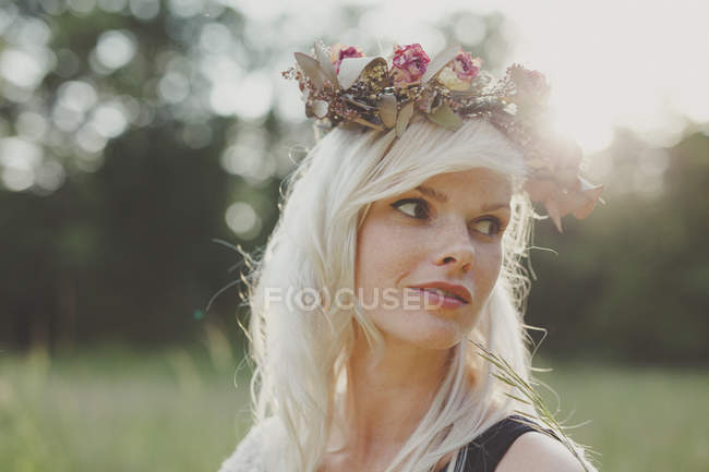 Girl with flowers in her hair during sunset — Stock Photo