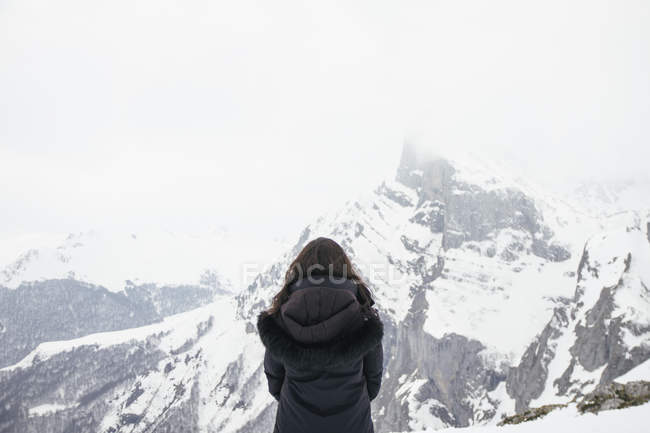 Donna di fronte a una montagna innevata a Picos de Europa — Foto stock