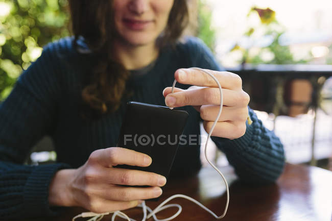 Giovane donna sul balcone ascoltare musica con smart phone — Foto stock