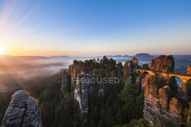 Germania, Sassonia, Parco nazionale della Svizzera sassone, Monti dell'Elba e ponte Bastei all'alba — Foto stock