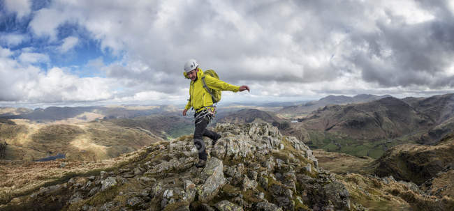 Inghilterra, Cumbria, Lake District, Langdale, Harrison Stickle, scalatore che cammina sulla roccia — Foto stock
