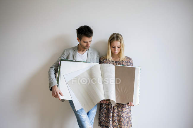 Couple with catalog selecting wallpaper — Stock Photo
