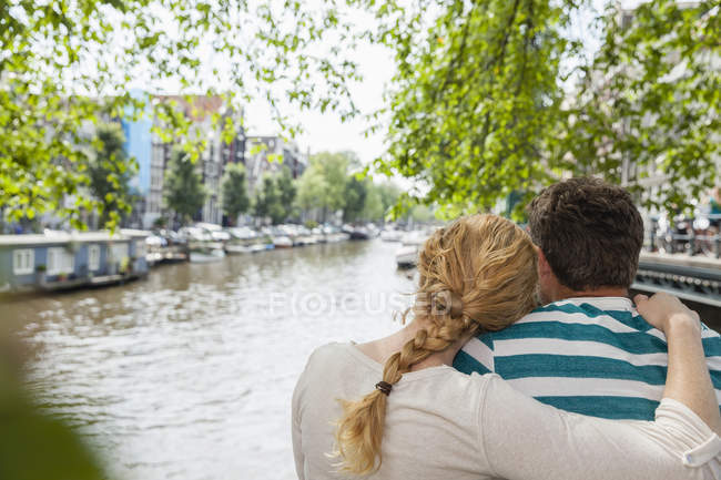 Pays-Bas, Amsterdam, couple embrassant au canal de la ville — Photo de stock
