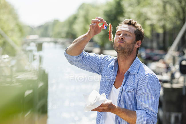 Pays-Bas, Amsterdam, homme mangeant du hareng matjes — Photo de stock