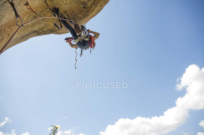 Climber climbing a rock using aid climbing techniques — challenge ...