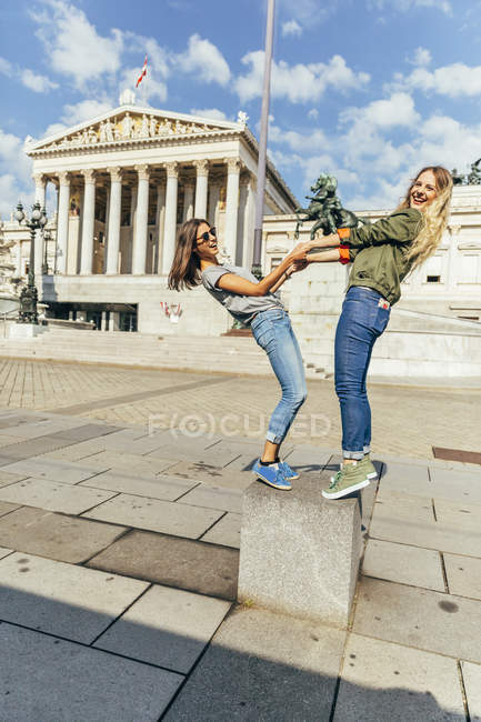 Австрия, Вена, две девушки веселятся перед зданием парламента — стоковое фото