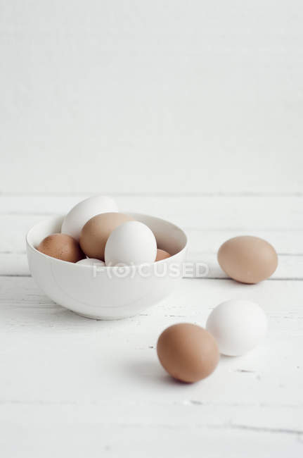 Bowl of white and brown eggs — Stock Photo