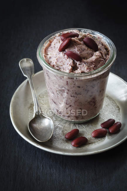 Glass of kidney bean spread with spoon — Stock Photo