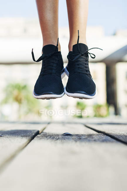 Женские ноги в черных кроссовках — Жизненность, гибкость - Stock Photo