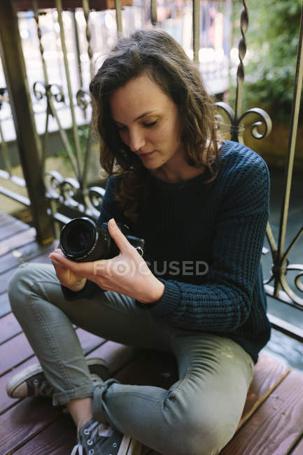 Молода жінка на балконі, використовуючи vintage камери — стокове фото