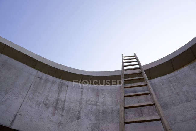 Лестница у бетонной стены незавершенного здания — стоковое фото