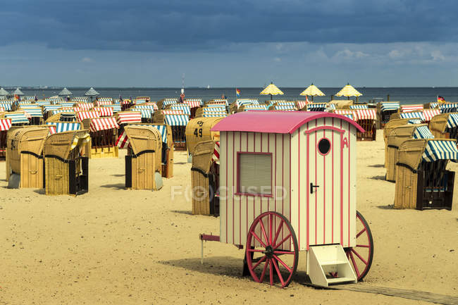 Плетеные плетеные пляжные стулья и кабинки для переодевания, Травемуэнде, Шлезвиг-Гольштейн, Германия — стоковое фото
