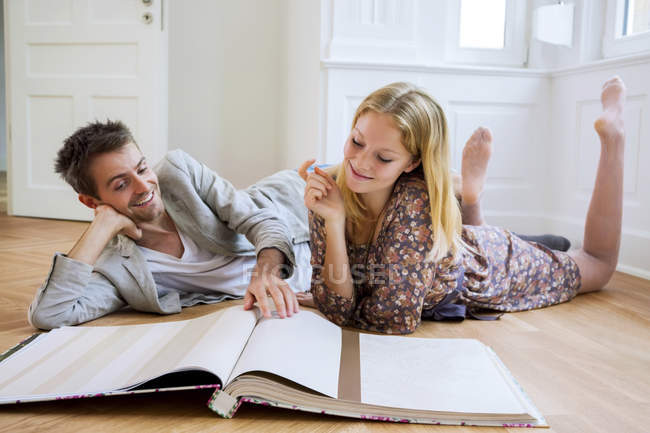 Couple selecting wallpaper from catalog — Stock Photo