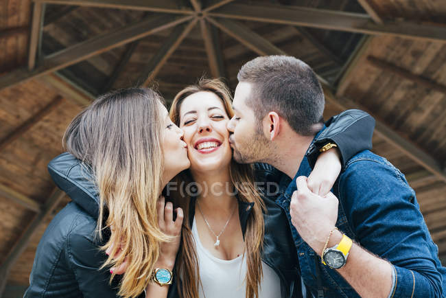 Giovane donna e un giovane uomo baciare e abbracciare amico femminile — Foto stock