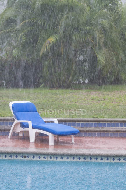 Mexico, Nayarit, heavy summer rain in residential backyard with swimming pool — Stock Photo