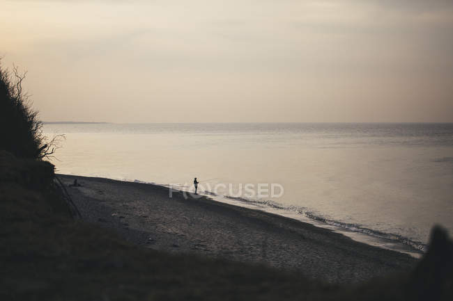 Germany, Nienhagen, view to the beach with angler standing at seafront in the evening — Stock Photo