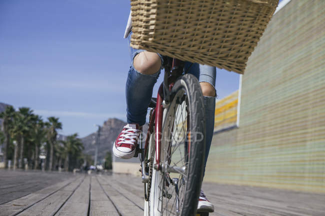 Молодая женщина на велосипеде с корзиной, низкий раздел — стоковое фото