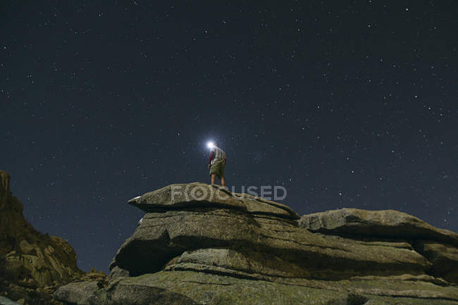 Spanien, Mann mit Stirnlampe unter einem Sternenhimmel auf einem Felsen in la pedriza — Stockfoto