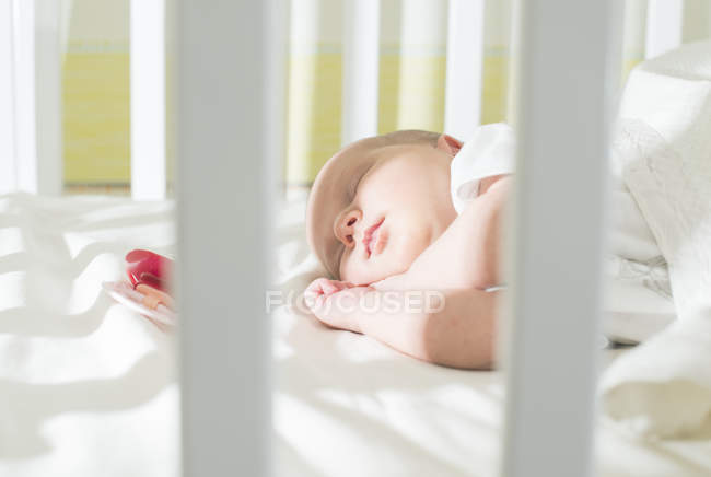 Gros plan de mignon sommeil bébé fille dans le lit — Photo de stock