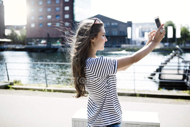 Jeune femme prenant un selfie avec smartphone — Photo de stock