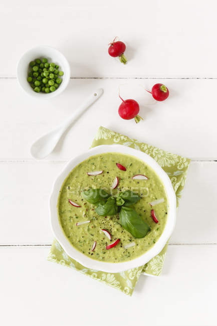 Soup dish of pea soup with radishes garnished with basil leaves — Stock Photo