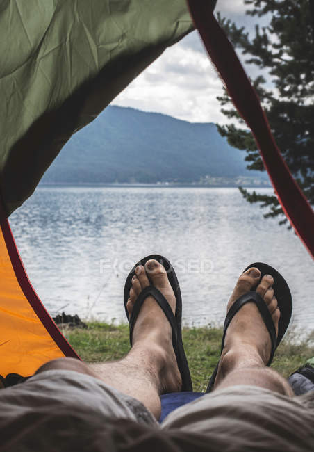 Bulgarie, jambe d'homme dans une tente avec vue sur l'eau — Photo de stock