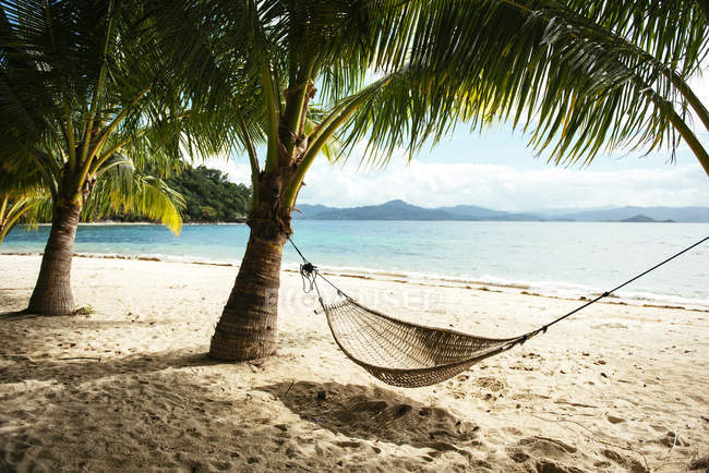 View of hammock and palms on beach near El Nido at daytime, Palawan, Philippines — Stock Photo