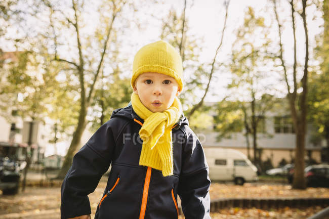 Porträt eines kleinen Jungen mit gelbem Schal und Hut auf der Straße — Stockfoto