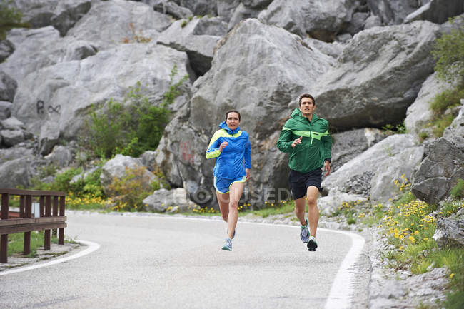 Couple running on road — Stock Photo