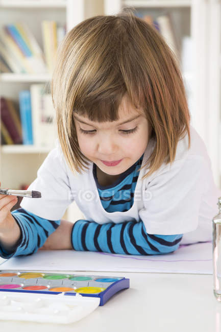 Portrait of little girl with paint box and brush — Stock Photo