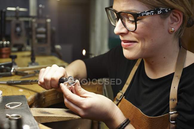 Orfèvre en atelier travaillant sur un bijou en forme de cœur — Photo de stock