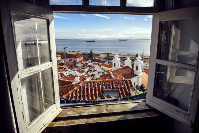 Portogallo, Lisbona, veduta del quartiere Alfama e del fiume Tejo attraverso una finestra aperta — Foto stock