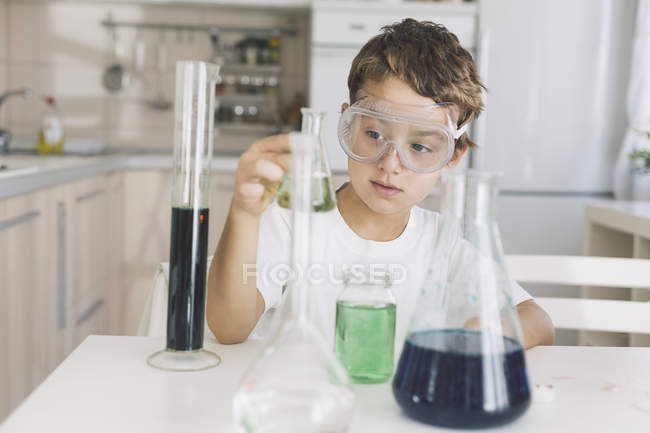 Chico jugando experimentos científicos en casa - foto de stock