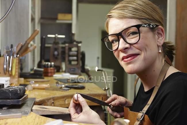 Portrait d'orfèvre en atelier au travail souriant à la caméra — Photo de stock