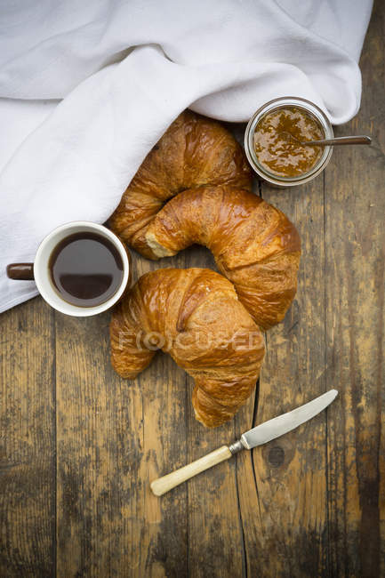 Croissants, confiture de figue, couteau et tasse de café noir — Photo de stock