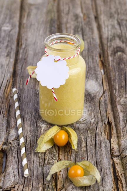 Bicchiere di frullato di physalis con physalis fresco e paglia su legno — Foto stock